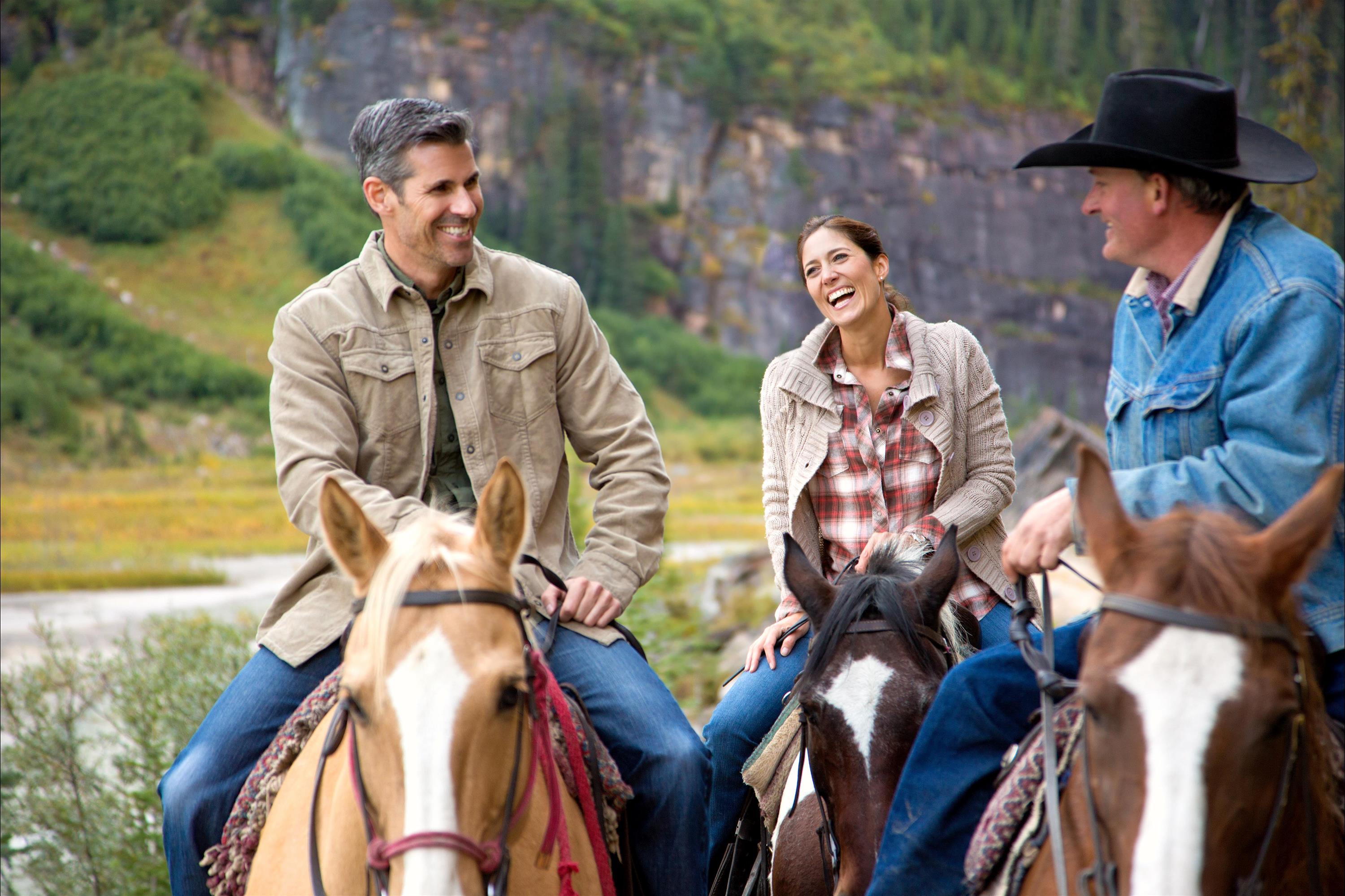 Three people horseback riding near Lake Louise