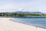 A sandy beach in Quebec City by the St. Lawrence River with rolling hills in the background