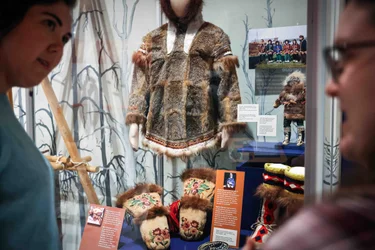 A man and a woman are looking at a display in a museum