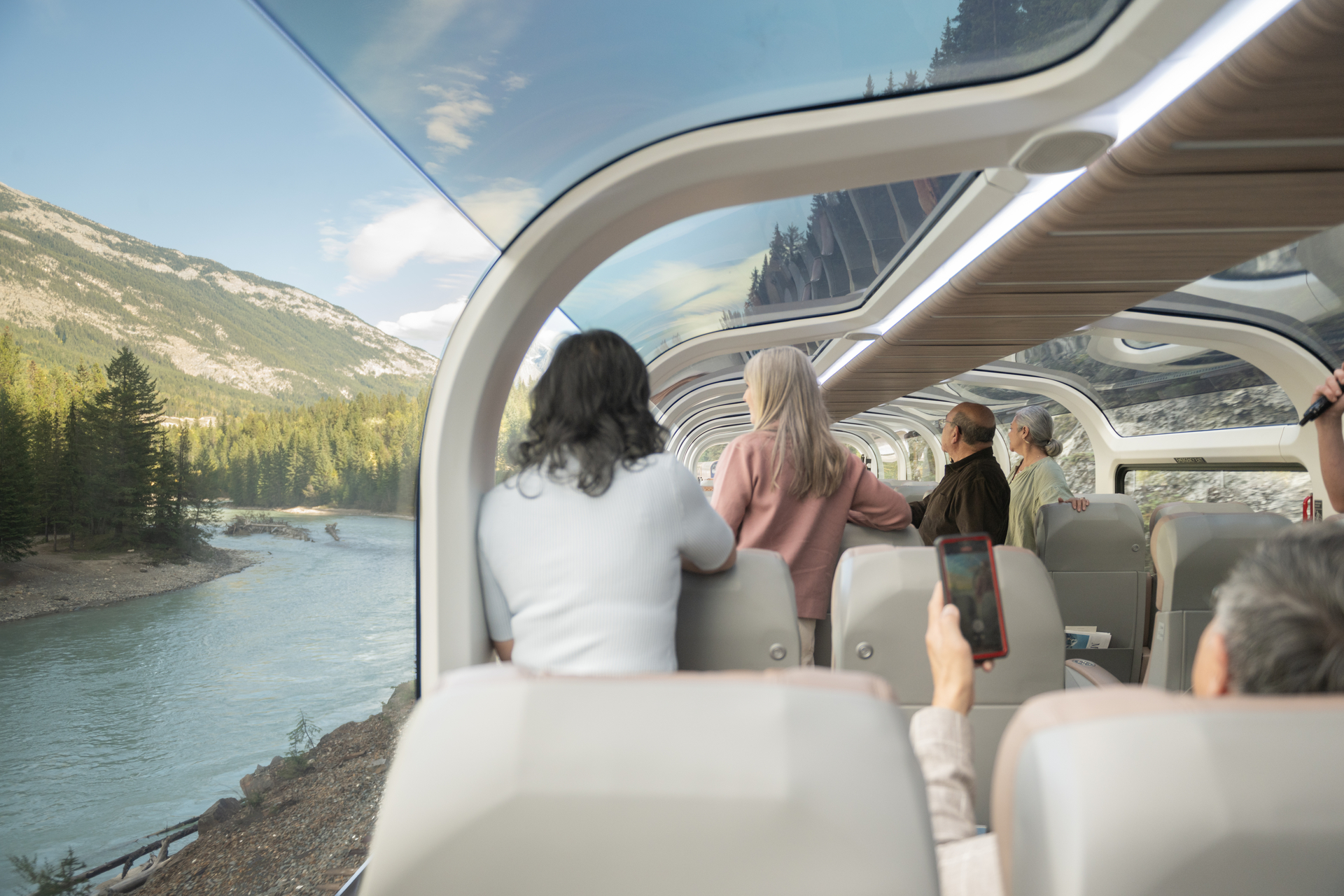 Guests looking at scenery from their seats in GoldLeaf onboard the Rocky Mountaineer Train
