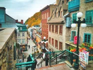 An elevated view from a set of stairs leading to streets with colourful buildings and warm-toned foliage in the background