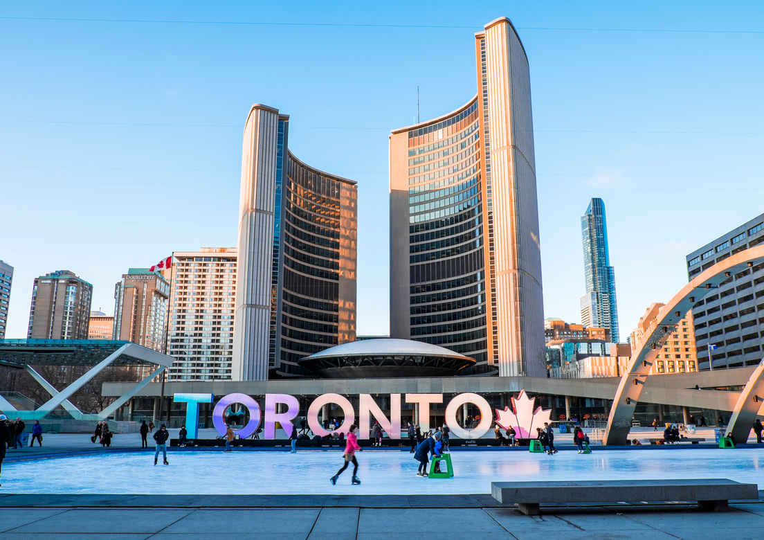 People ice skating in front of the Toronto sign in winter