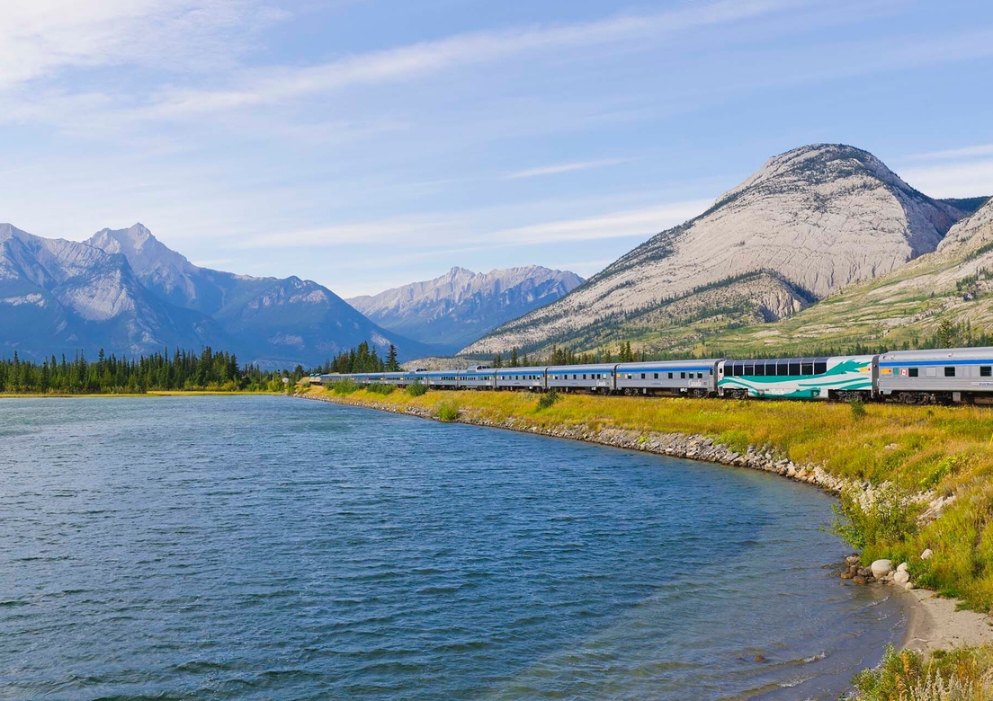 VIA Rail train with mountains in the background
