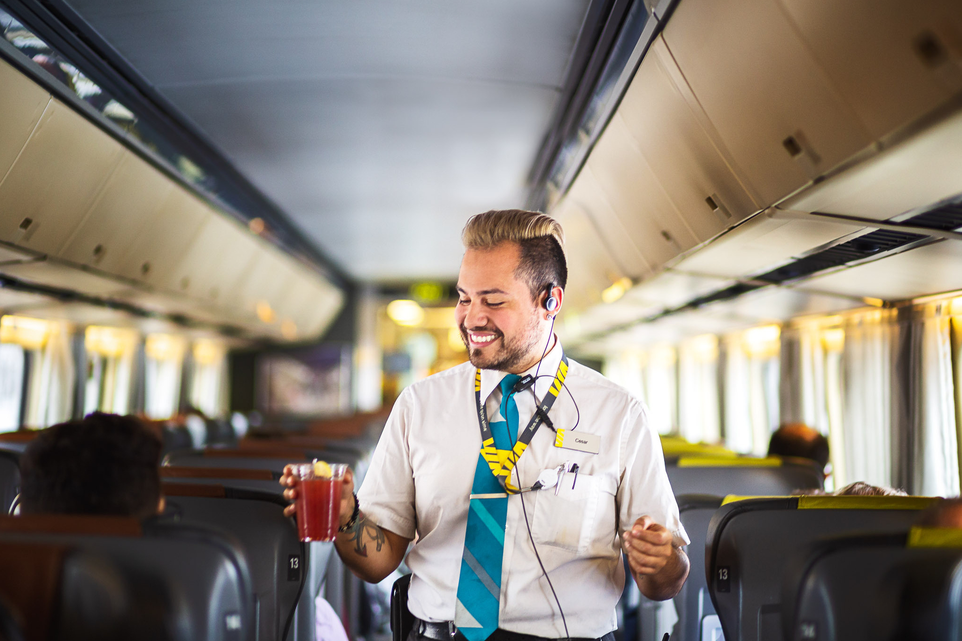 VIA Rail Train, employee on the corridor train walking through the aisle with a drink