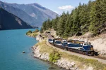 The Rocky Mountaineer rounds the bend alongside the azure waters of Seton Lake, BC.
