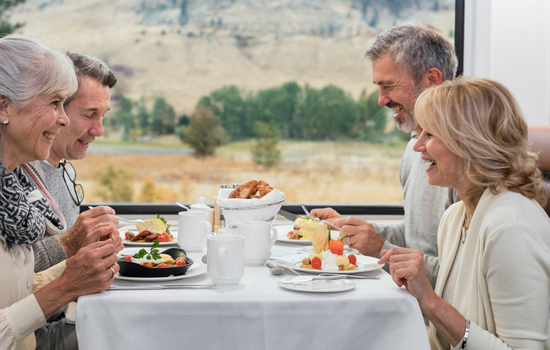 Couples enjoying breakfast in the dining room of the GoldLeaf coach on Rocky Mountaineer train