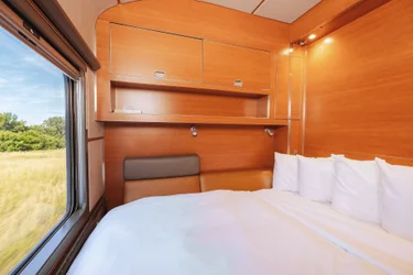 Made Murphy bed facing extra-large window of Prestige Sleeper cabin in VIA Rail's train, The Canadian, during winter