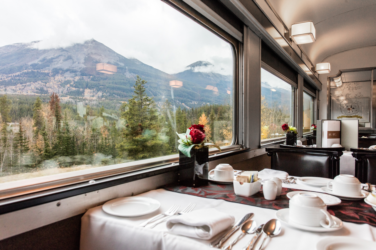 View of mountains from the window next to a table in the Dining Car of VIA Rail The Canadian train