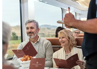 Onboard host taking meal order from guests in the GoldLeaf dining room