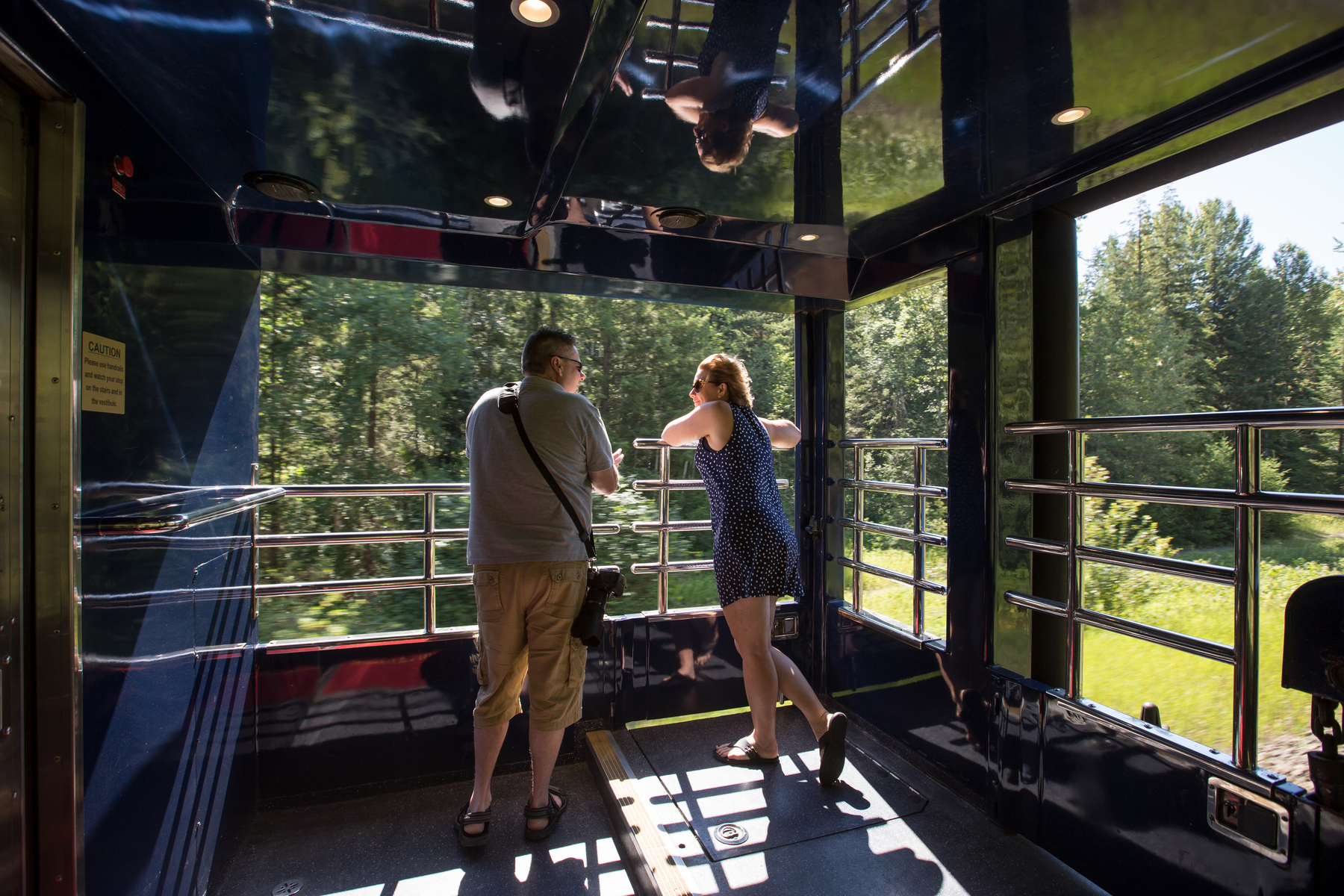 Couple standing on the large GoldLeaf outdoor viewing platform on Rocky Mountaineer