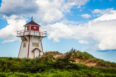 Small lighthouse on a red sand beach on Prince Edward Island