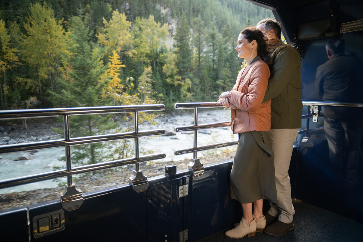 Guests looking at scenery from the outdoor viewing platform on a Rocky Mountaineer GoldLeaf coach