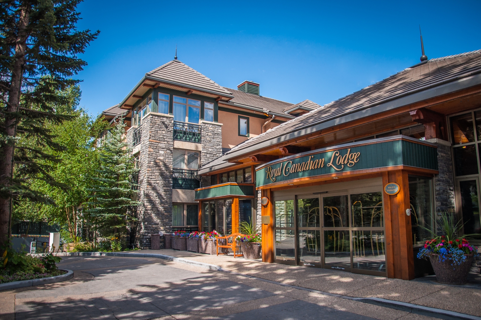 Exterior of Royal Canadian Lodge in the summer with trees and blue sky