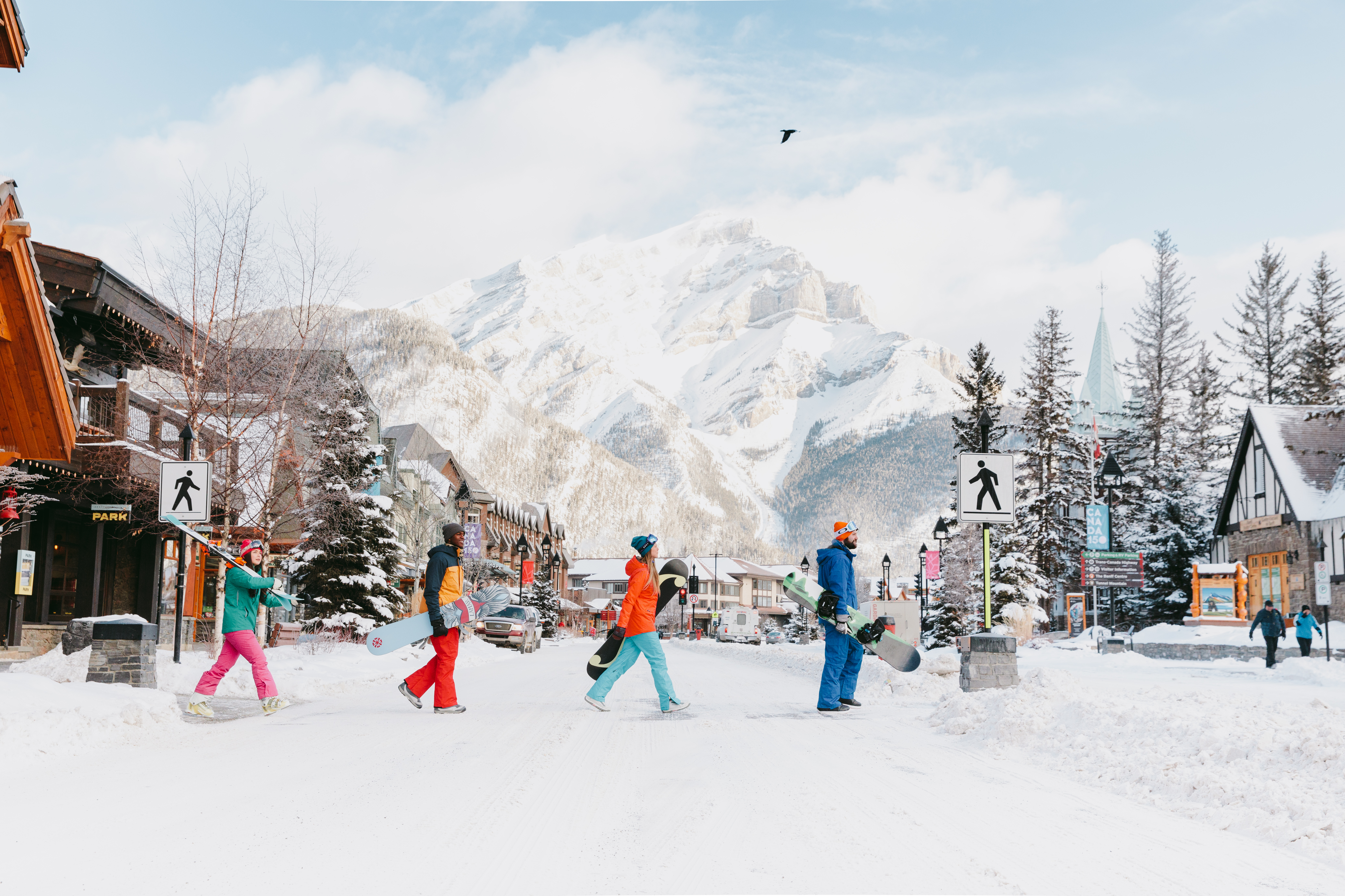 Snowboarders crossing the snowy street of Banff
