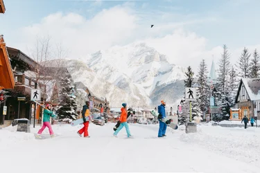 Snowboarders crossing the snowy street of Banff