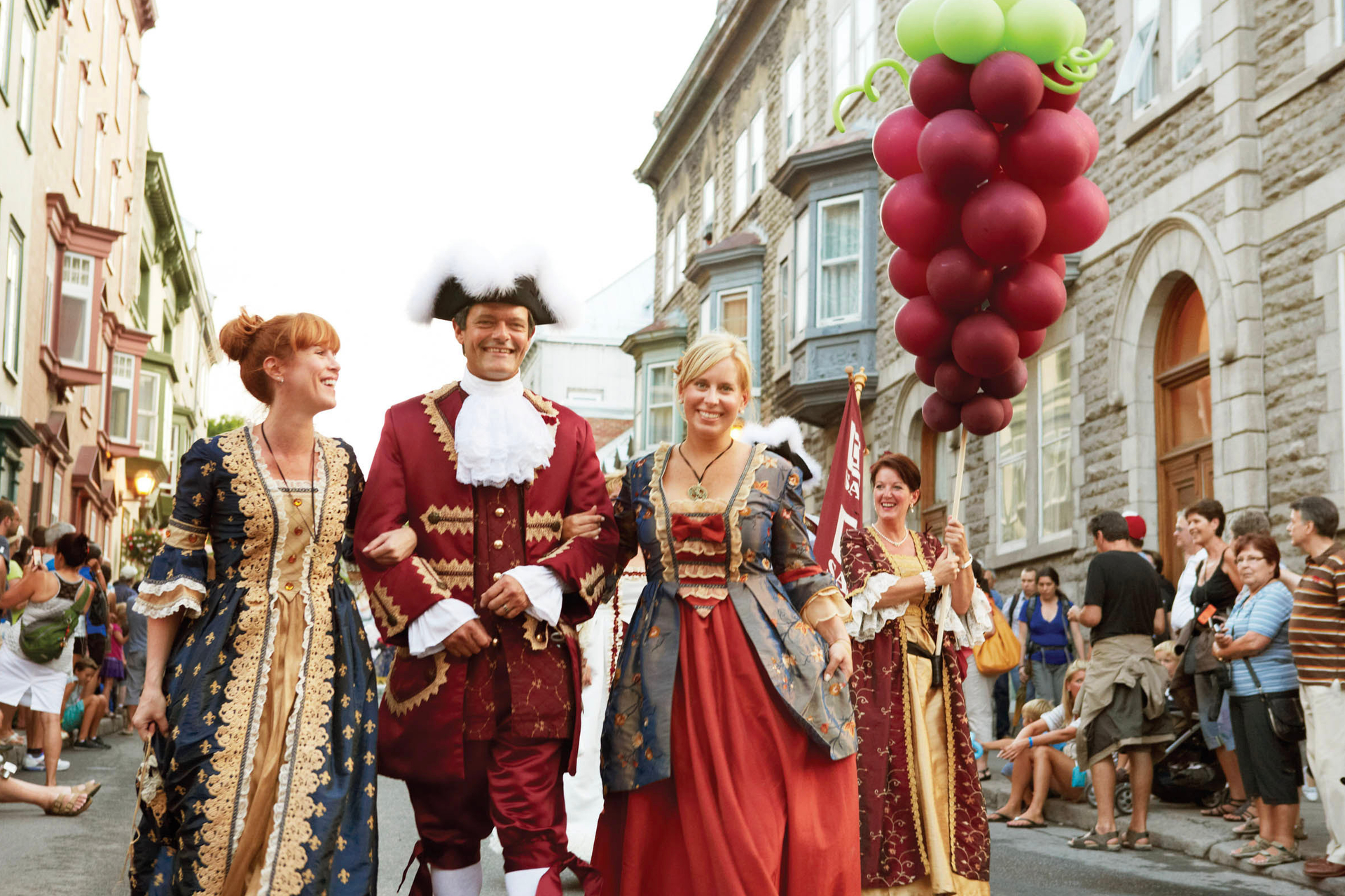 A group of three people dressed up in traditional French Canadian clothing