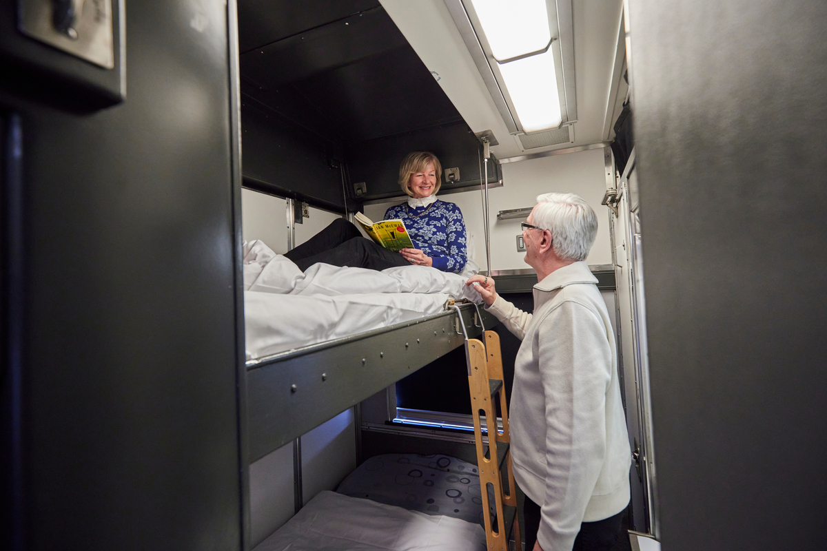 Couple in the bunk beds of a Sleeper Cabin for two on VIA Rail