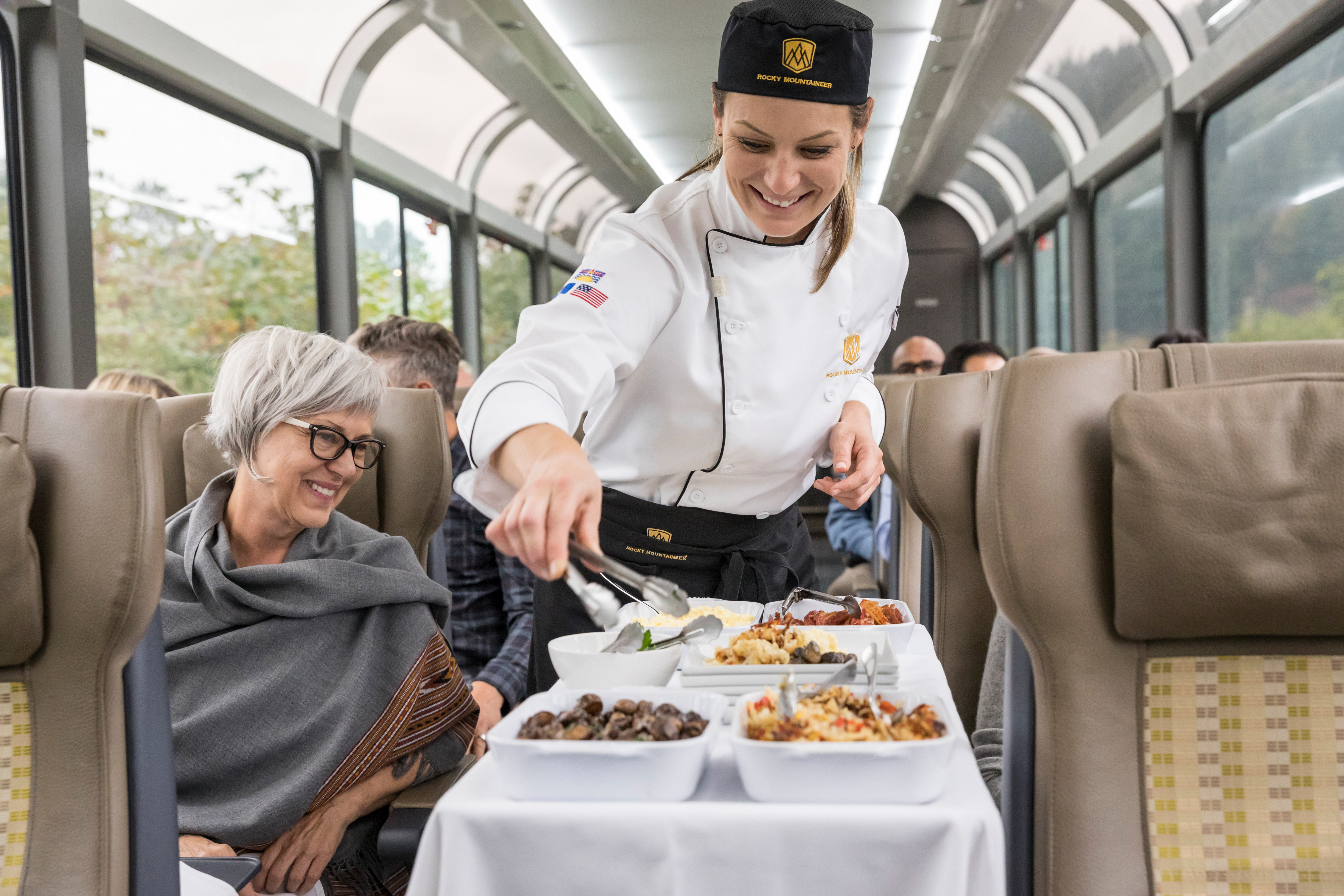 Chef serving lunch seatside in SilverLeaf coach.