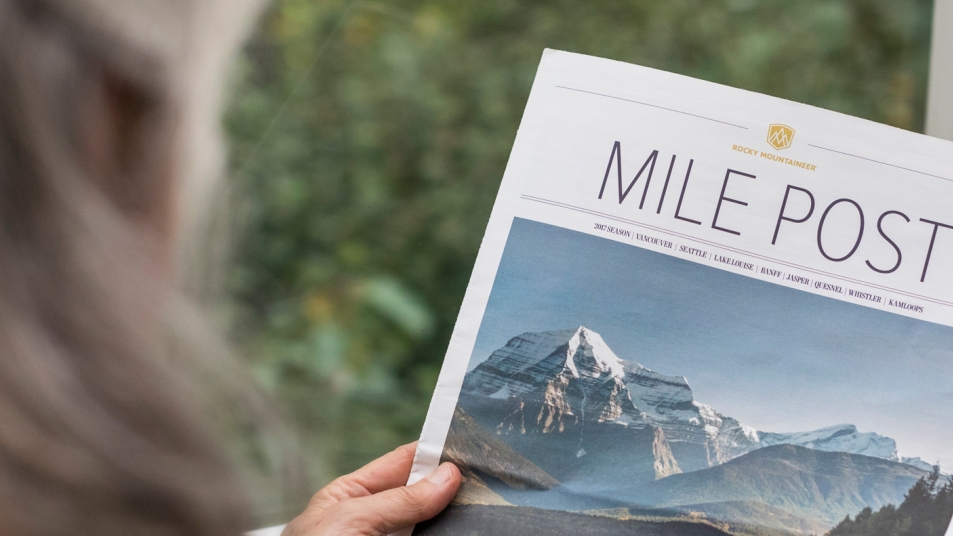Passenger reading Mile Post onboard the Rocky Mountaineer