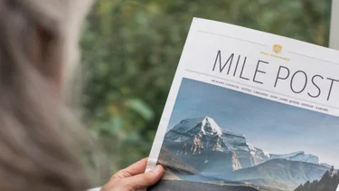 Passenger reading Mile Post onboard the Rocky Mountaineer