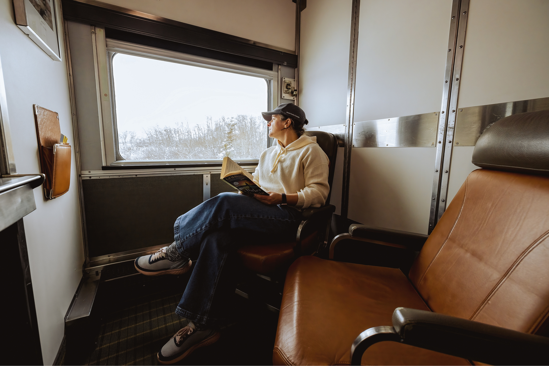 Woman sitting in a sleeper cabin for two on VIA Rail Canadian train 