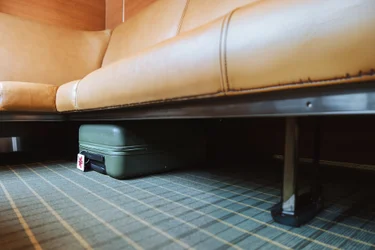Baggage placed under couch in Prestige class cabin onboard VIA Rail's train, The Canadian