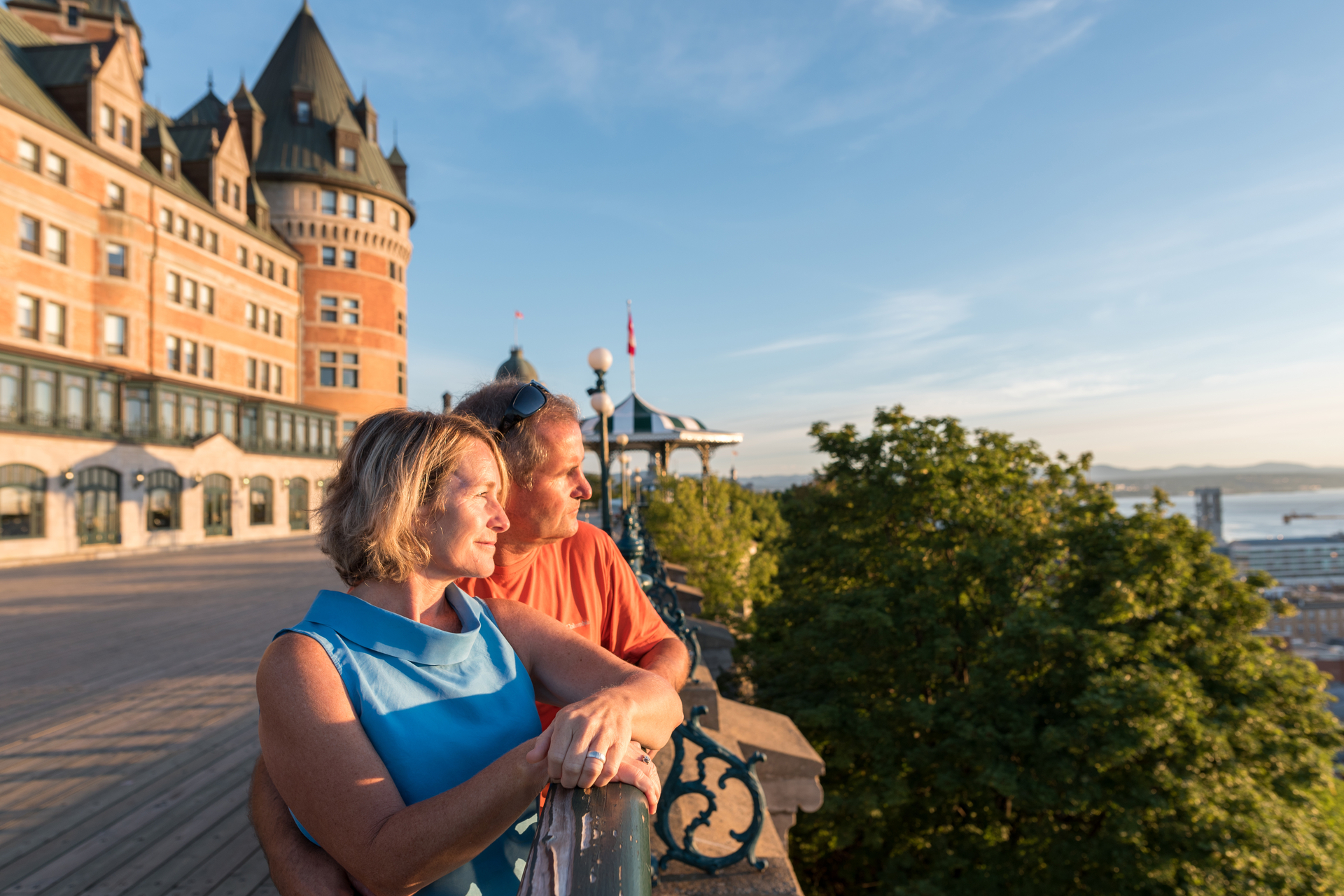 A mature couple looks out over Dufferin Terrace in front of the Fairmont Chateau Frontenac in Quebec City