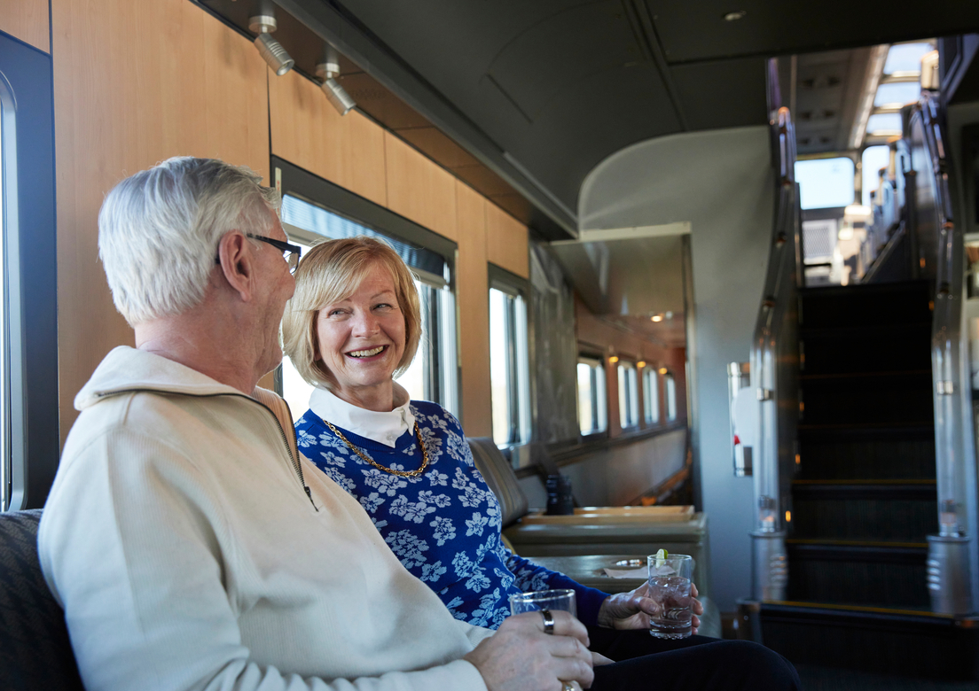 Couple enjoying a drink on VIA Rail train in the lounge