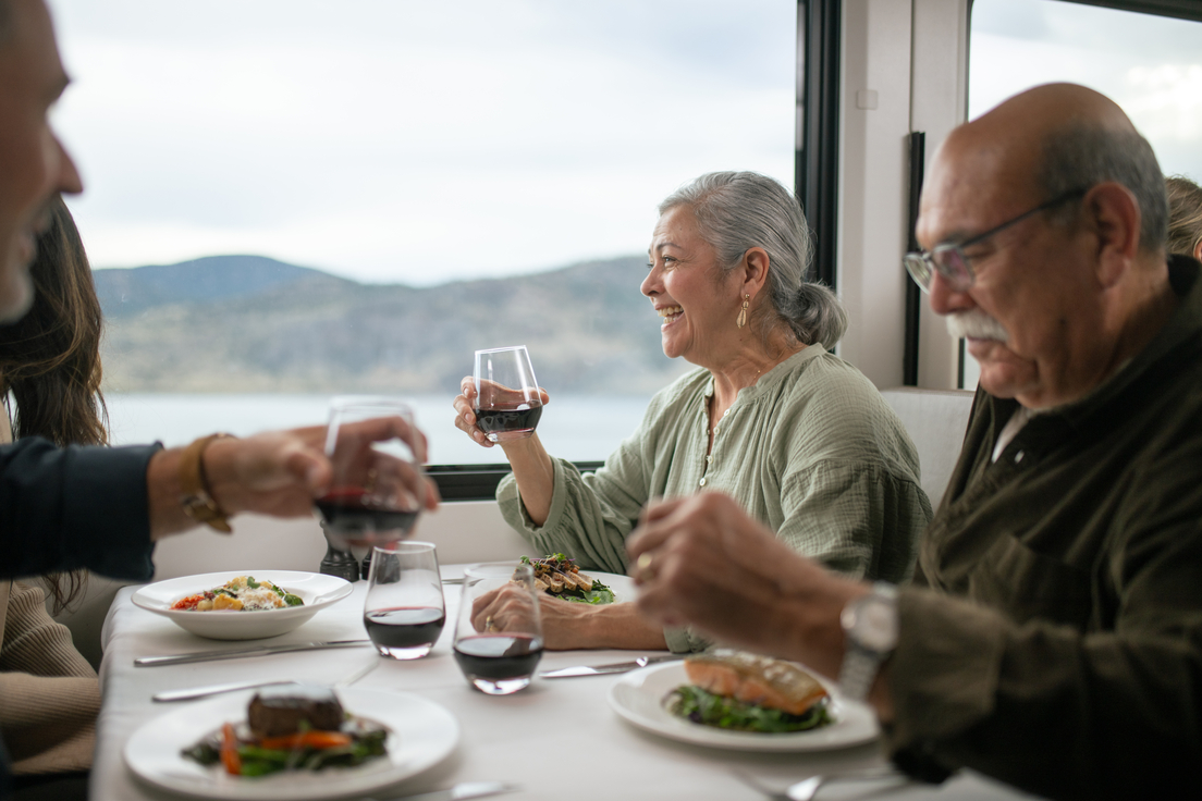 Guests smiling while eating lunch in the GoldLeaf service dining room on Rocky Mountaineer 