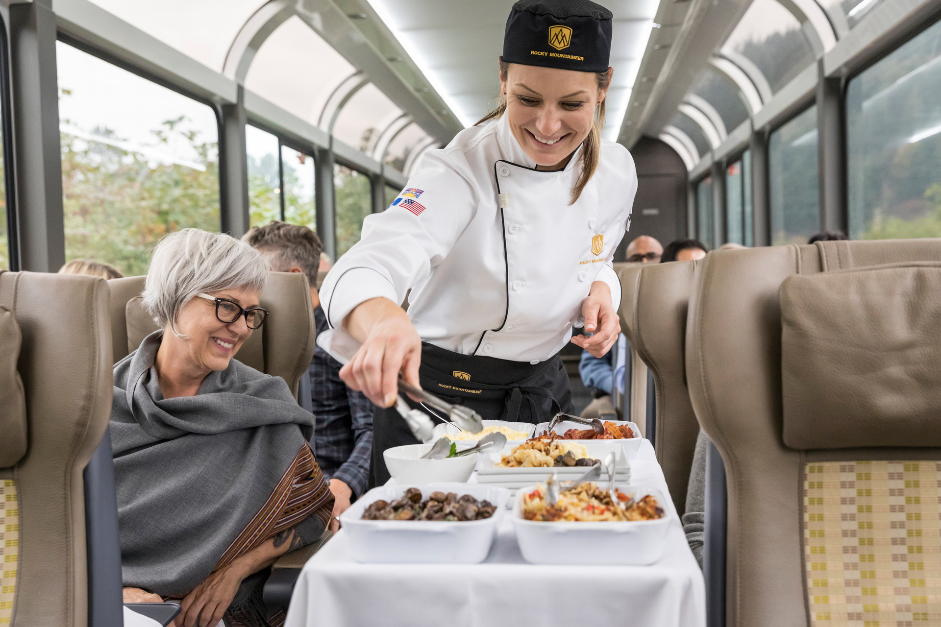 Chef serving lunch seatside in SilverLeaf coach.