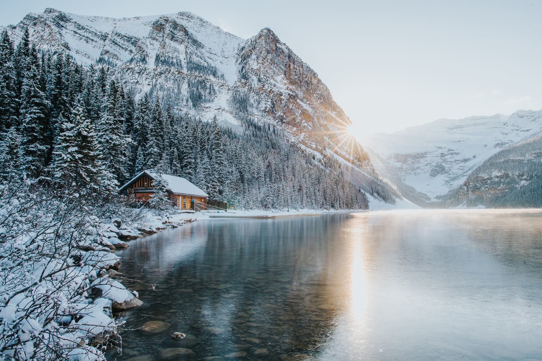 Sunset over frozen Lake Louise with snow-capped mountains in winter