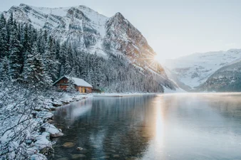 Sunset over frozen Lake Louise with snow-capped mountains in winter