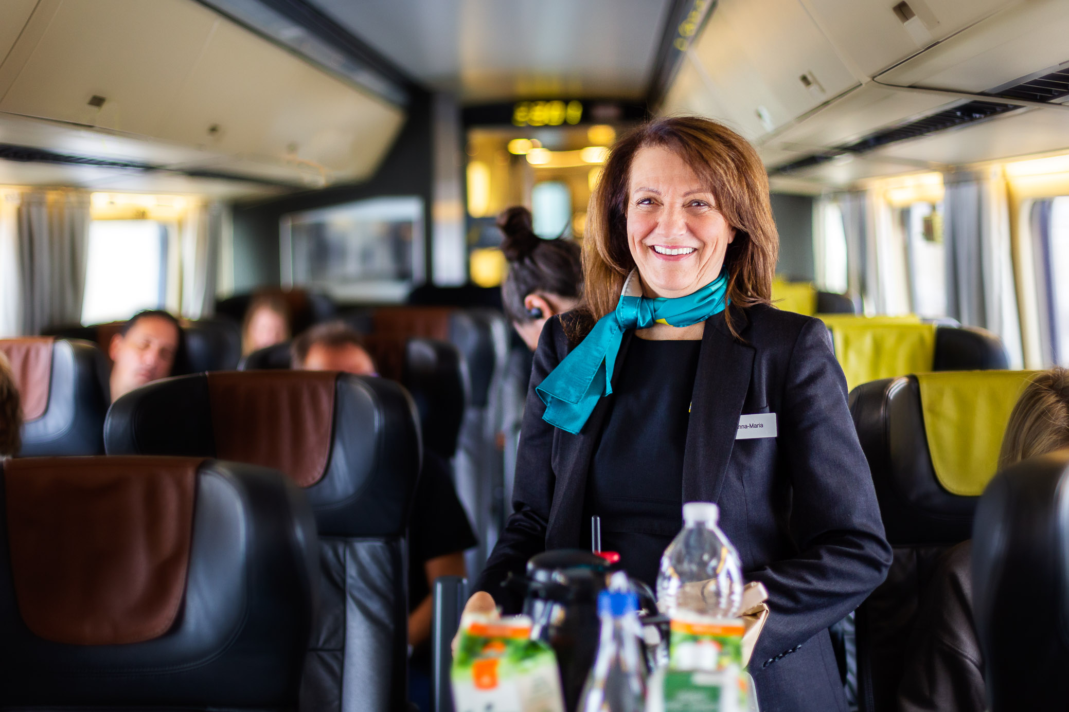 VIA Rail train, employee serving water and smiling