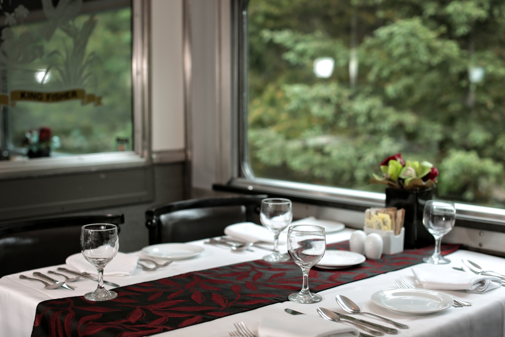 Table settings in the dining car on the Canadian train with view of trees out the window