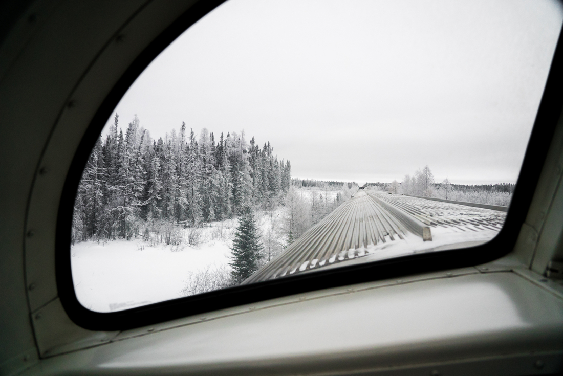 View from a train window going through snowy scenery during a winter trip. 