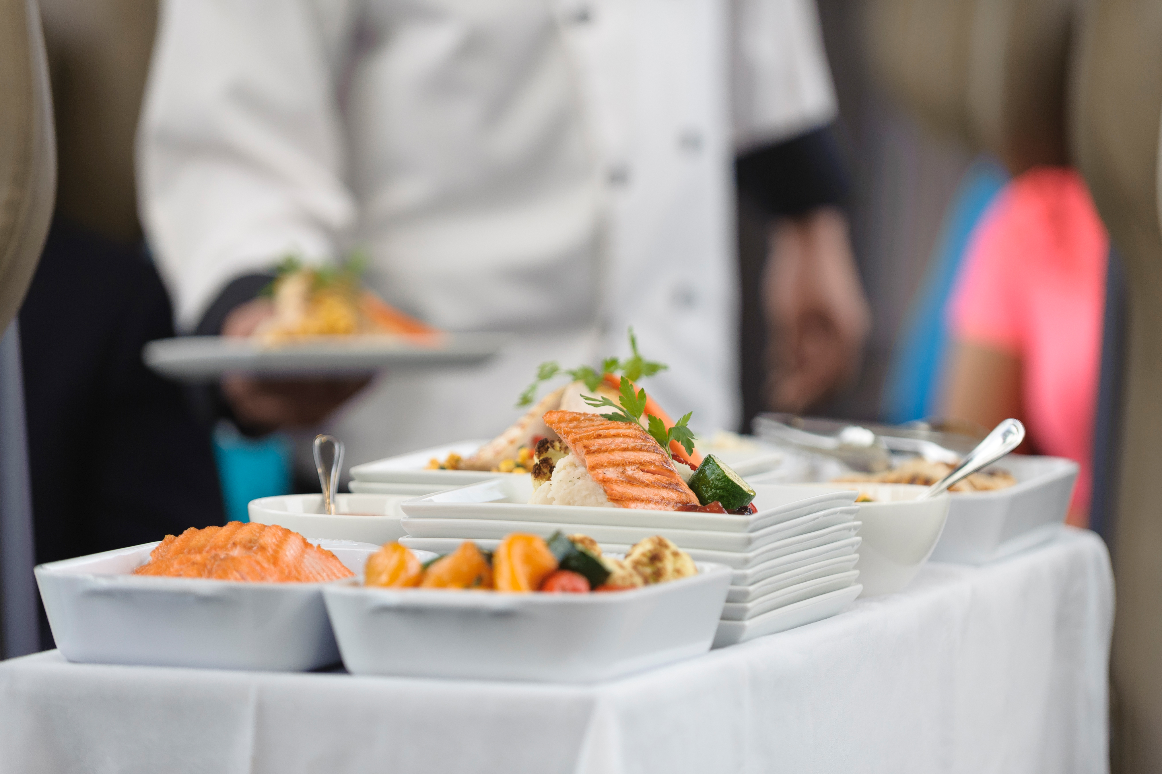 A close up of a meal cart loaded with dishes of Salmon.
