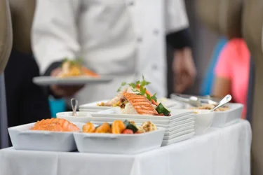 A close up of a meal cart loaded with dishes of Salmon.