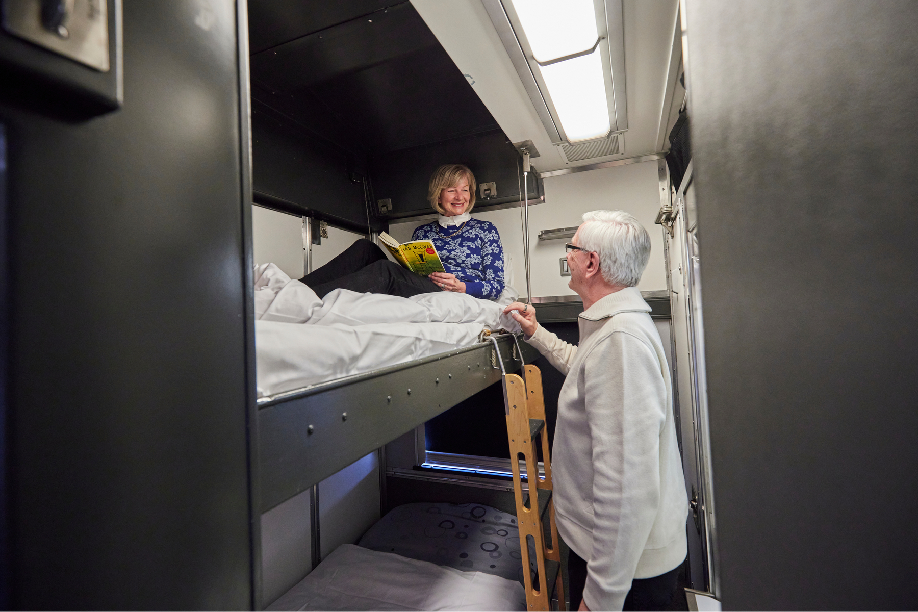 Couple by the bunk beds in a private sleeper cabin on VIA Rail Canadian train
