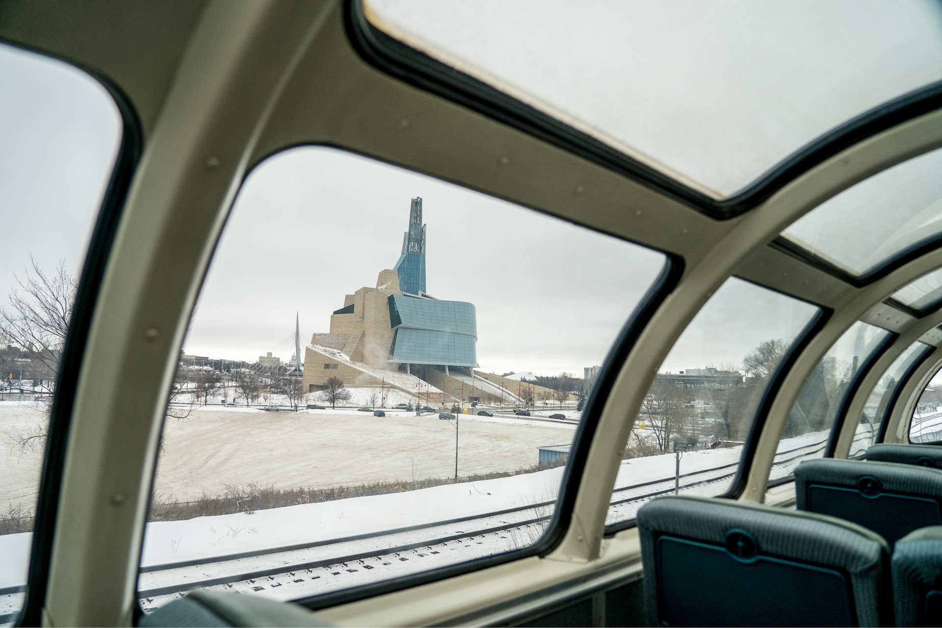 Inside a viewing car on VIA Rail's Winnipeg to Churchill train, looking out at the Canadian Museum for Human Rights