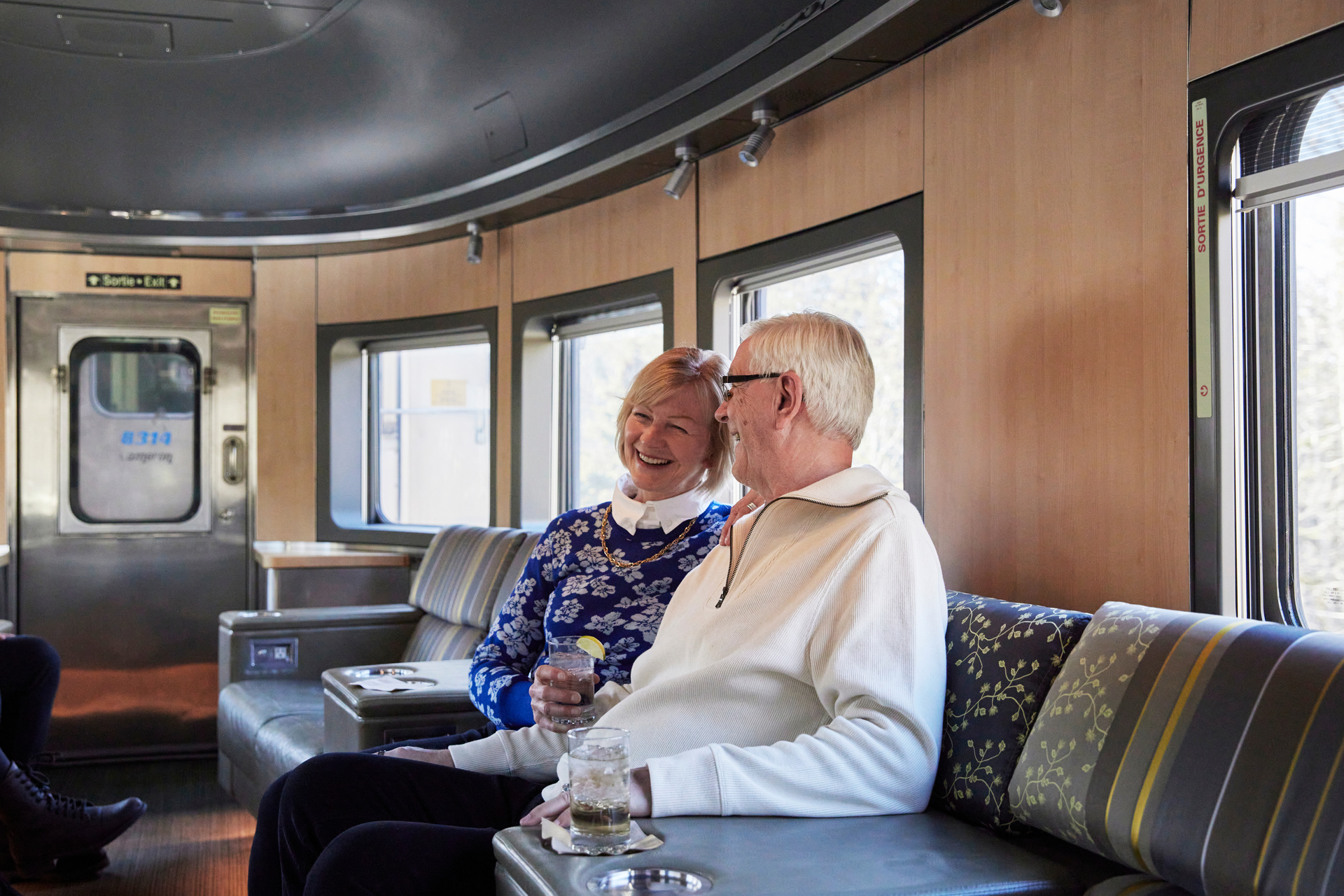 Couple enjoying a drink on VIA Rail train in lounge