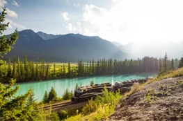 Rocky Mountaineer train alongside a lake in the Canadian Rocky Mountains