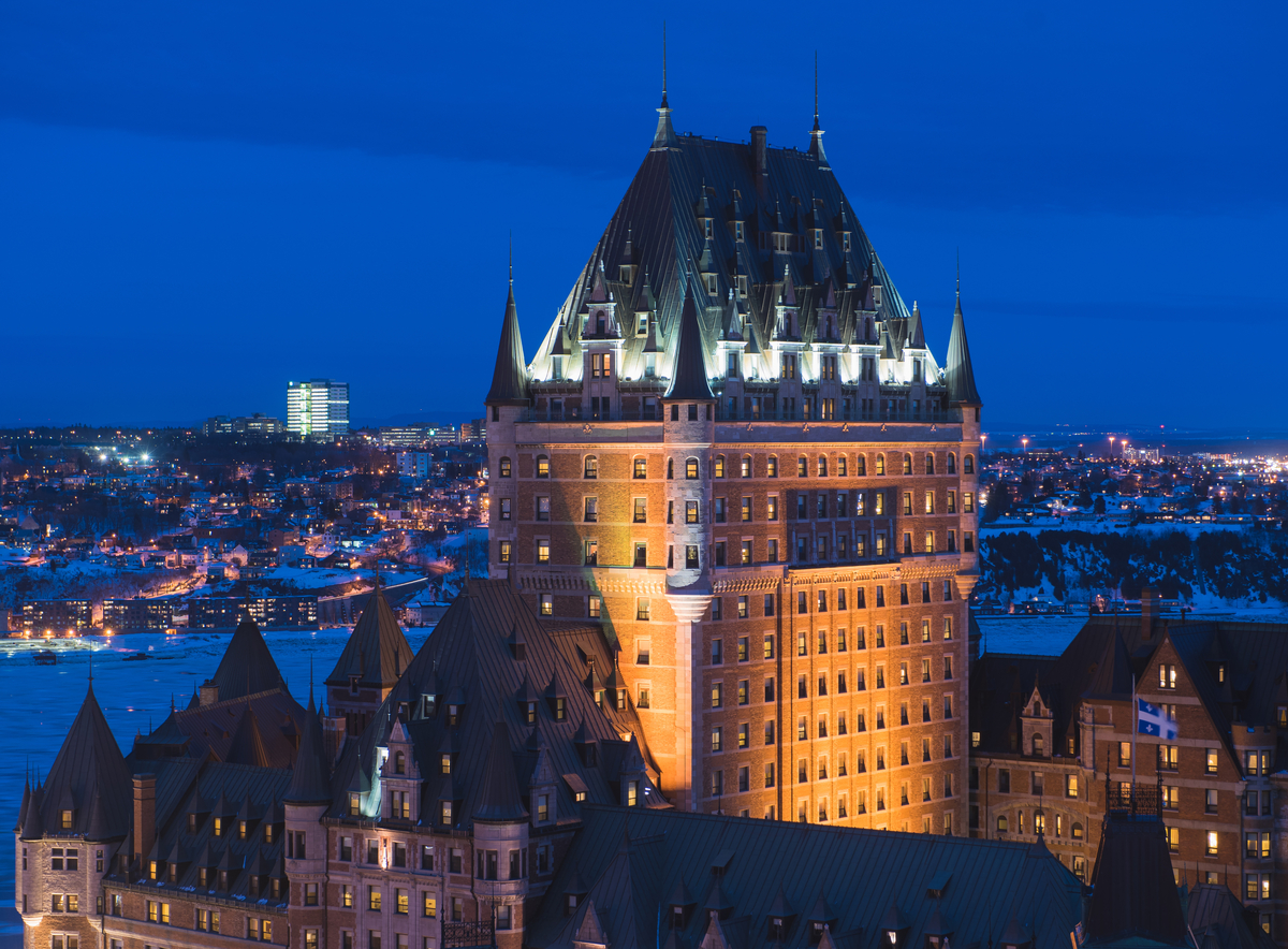 Fairmont Le Château Frontenac illuminated at night overlooking Quebec City. 