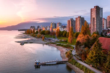 Vancouver sea wall and city skyline with mountains and ocean at sunset
