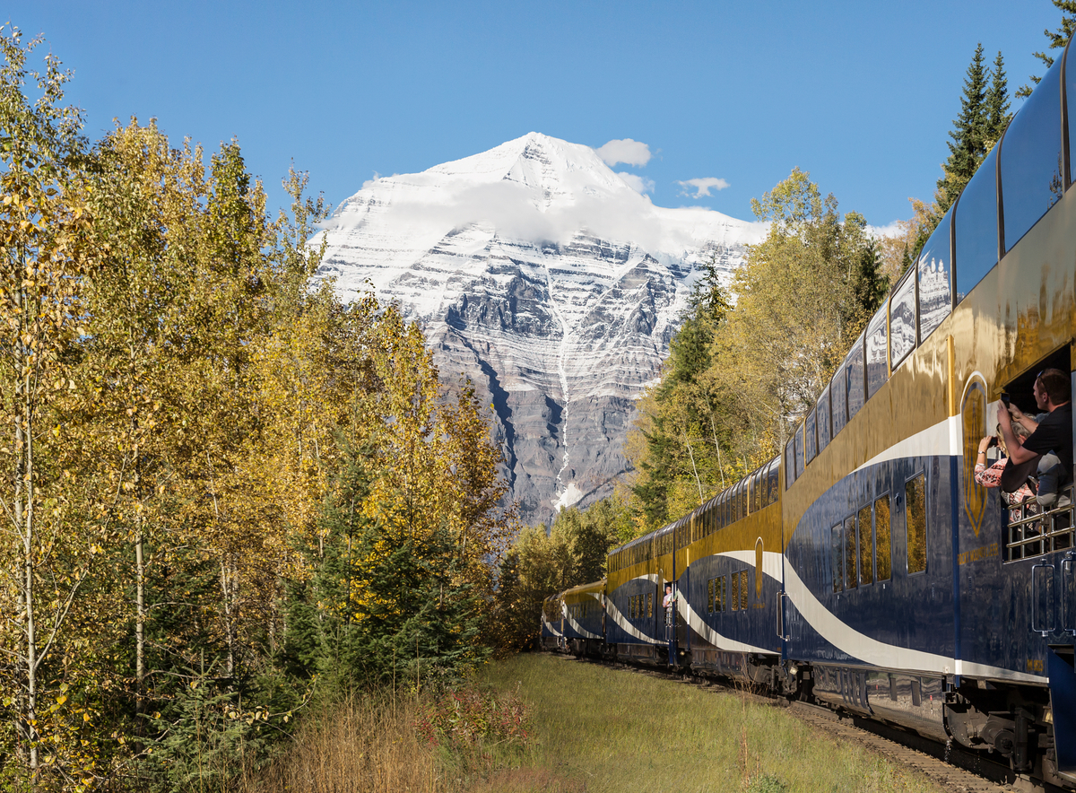 Guests capturing photos of Mount Robson from the GoldLeaf service vestibule on the Journey Through the Clouds route