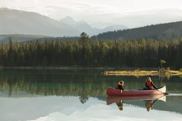 Caucasian mother and daughter canoeing on Lake Edith