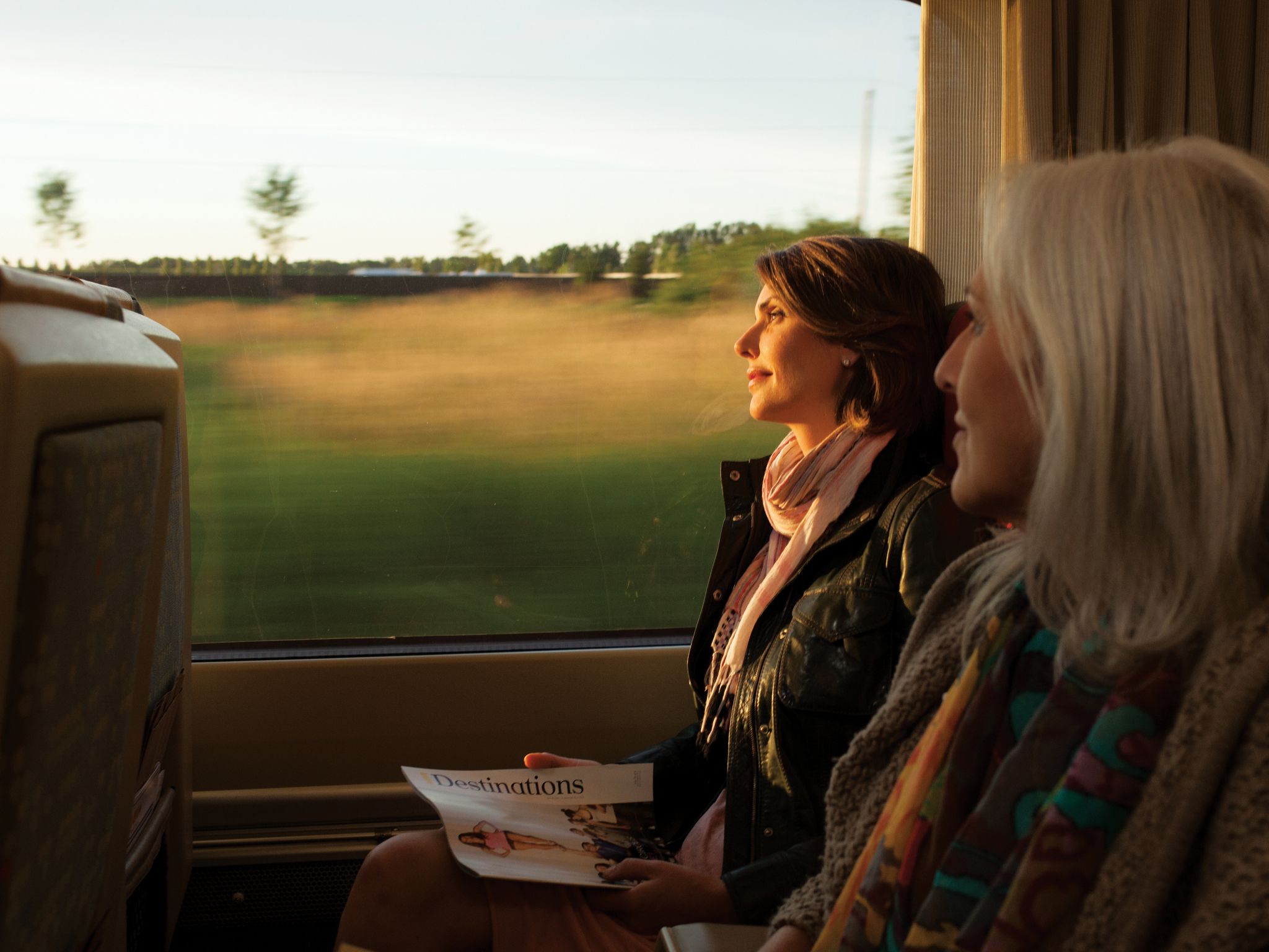 Two women riding the train at sunset