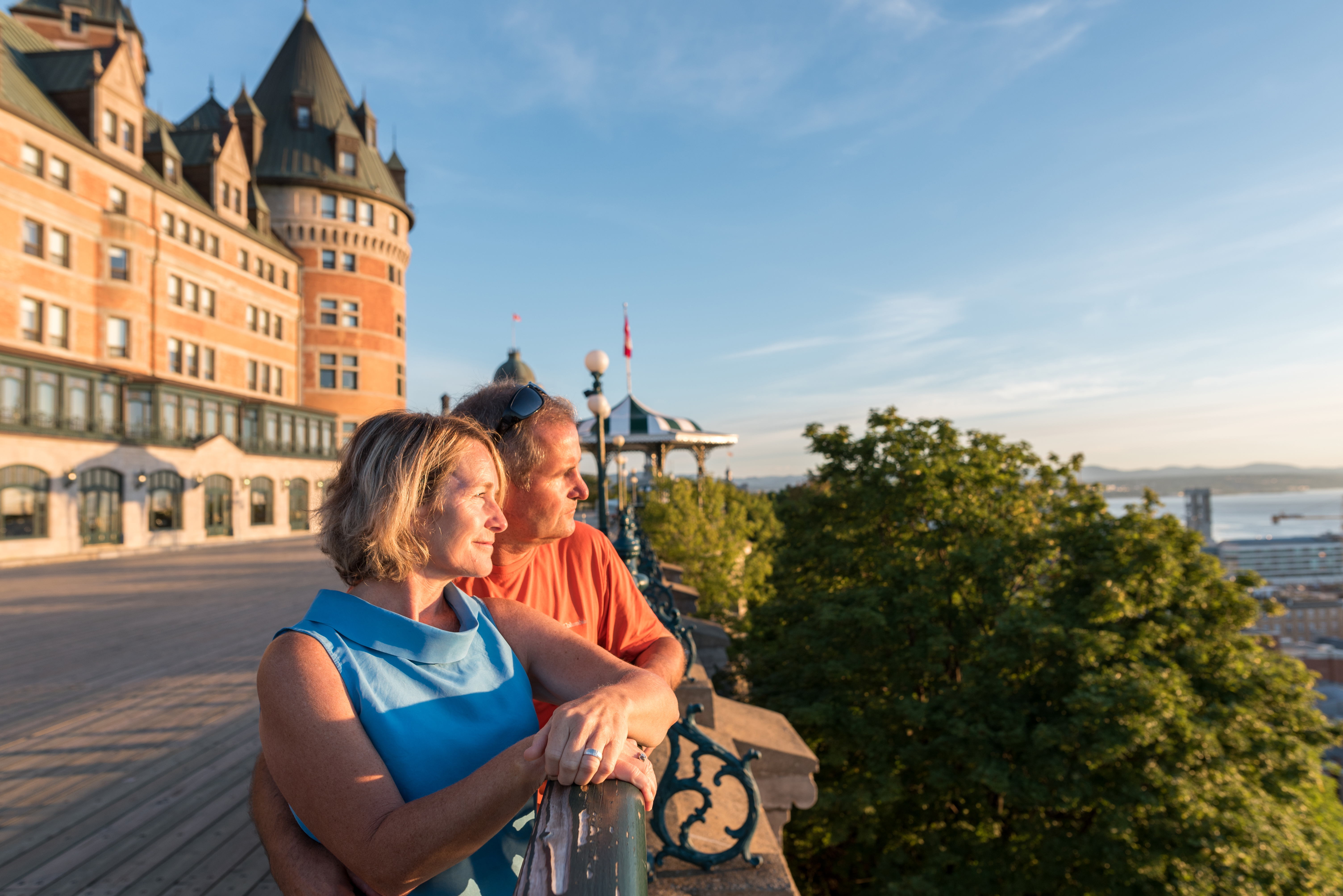 A mature couple admires the view over Dufferin Terrace in Quebec City with the Fairmont Chateau Frontenac in behind