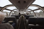 Passengers in scenic dome section on the top floor of Sleeper Plus class Skyline car onboard VIA Rail's train, The Canadian, during winter
