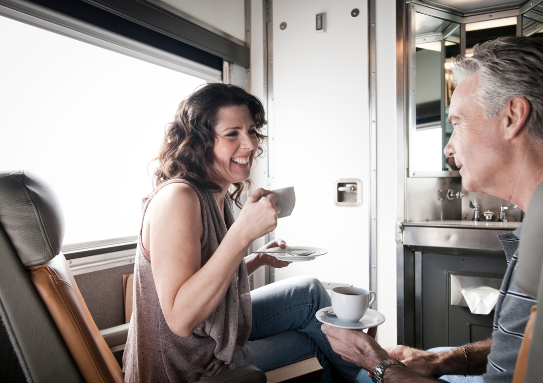 Man and woman enjoy a cup of coffee in VIA sleeper car