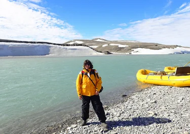 Woman in Nunavut by the water on an Arctic Watch Adventure